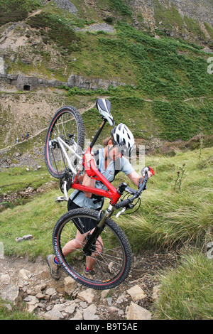Junge Reiterin mit Mountain-Bike einen steilen, felsigen Pfad vor alten Bleiminen in Yorkshire Dales Stockfoto