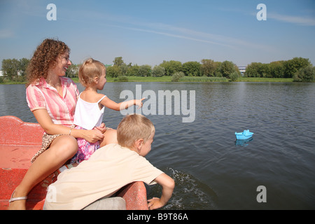 Mutter mit den Kindern in das Boot und das Spielzeug Schiff Stockfoto