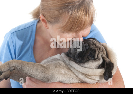 Reife Dame kuscheln einen Mops Hund isoliert auf weißem Hintergrund Stockfoto