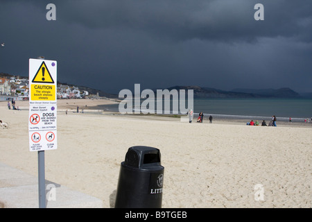 schwarze Gewitterwolken sammeln über Lyme Regis keine Hunde Schild Strand Dorset Küste Stadt England uk gb Stockfoto