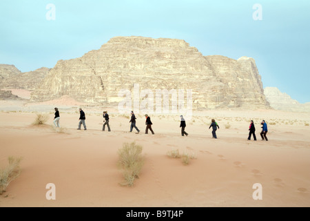 Jordantouristen; Menschen, die bei Sonnenaufgang in der Wüste in einer Schlange herumlaufen, Wadi Rum, Jordanien, Naher Osten Stockfoto