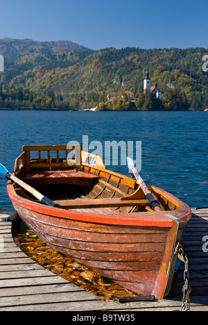 Blick auf ein kleines Boot und die Annahme von Mary Wallfahrtskirche als Hintergrund im Herbst, Bled, Slowenien, Europa Stockfoto