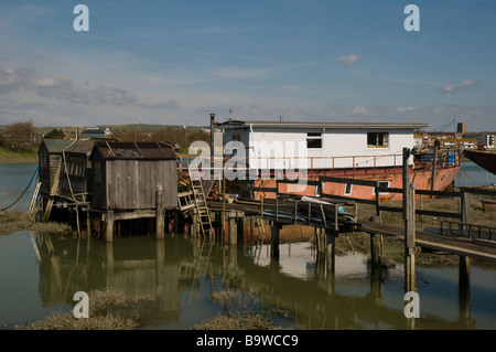 Eine marode aussehenden Holzponton auf Stelzen über Wasser, was zu einem Hausboot bei Shoreham in West Sussex, England. Stockfoto