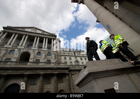 G20-Demonstration Londoner Polizeibeamte an der Wand von Royal Exchange, die Demonstranten vor der Bank of England, Threadneedle Street, London, 2009 beobachteten Stockfoto