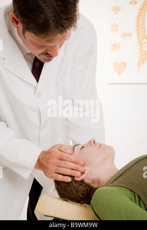Chiropraktiker sanft verstellen Hals einer Patienten während ein Büro zu besuchen Stockfoto