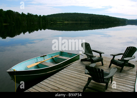 Drei hölzerne Adirondack Stühle auf einem Boot dock an einem wunderschönen See am Abend Stockfoto