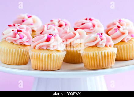 Viele leckere Muffins mit Zuckerguss auf Tablett Stockfoto