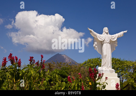 Statue von Jesus an der Cementerio Los Angeles in Moyogalpa, Nicaragua auf der Insel Ometepe mit der Volcan Concepcion hinter droht. Stockfoto