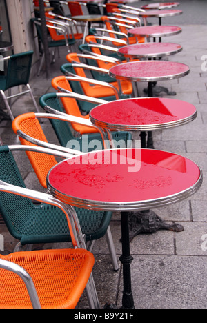 Leuchtend bunte Tische in einem Straßencafé mit Regen fällt Stockfoto
