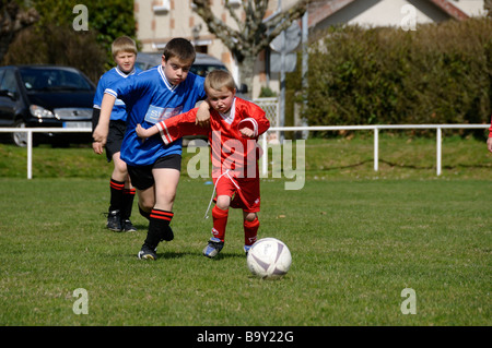 Stock Foto von zwei 9-jährigen Jungen zusammen laufen, beide versuchen, den Fußball Stockfoto