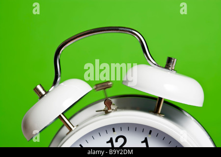 teilweise, geneigte Ansicht der klassischen weißen Doppel Glocke Wecker klingeln, grüner Hintergrund Stockfoto