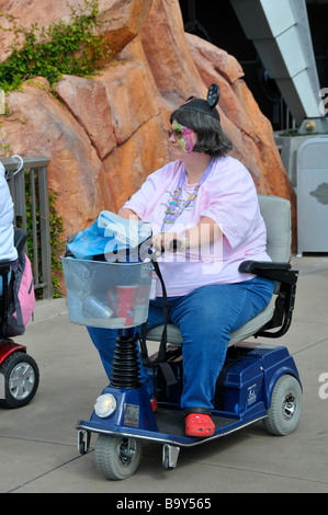 Übergewicht behinderten weiße Hündin mit Mäuseohren reitet Elektroroller an Disney Magic Kingdom Orlando Florida Stockfoto