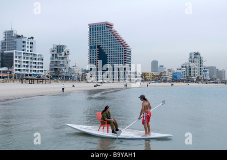 Israelische Soldatin sitzt auf dem sogenannten Hasake ein Brett - Boot Hybrid der Stand-up Paddle Familie in der mediterranen Küste von Tel Aviv, Israel Stockfoto