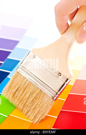 Hand mit Pinsel über Farbmuster Karte Stockfoto