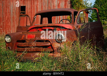 Ein rostiges rotes Auto im Feld mit Holzscheune in Michigan, USA, in den USA, in keiner horizontalen Hi-res Stockfoto