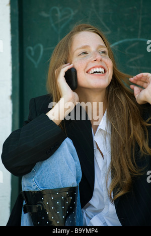 Junge Frau am Handy, mit Haaren spielen Stockfoto