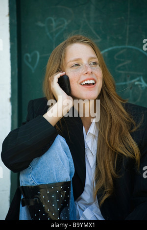 Junge Frau mit Strawberry blonde Haare, Sommersprossen, reden über Handy, Lächeln Stockfoto