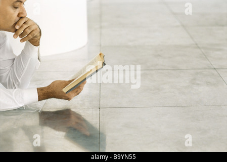 Senior woman liegen auf gefliesten Boden Buch Stockfoto