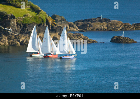 Troy Klasse Segelboote in Fluss Fowey Mündung Köpfen heraus zum Meer vorbei an Polruan. Stockfoto