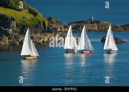 Troy Klasse Segelboote in Fluss Fowey Mündung Köpfen heraus zum Meer vorbei an Polruan. Stockfoto