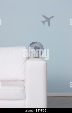 Globus am Arm des Sofas, Flugzeug im Hintergrund Stockfoto