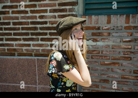 Junge Frau trägt trendige Hut und reden über Handy Stockfoto