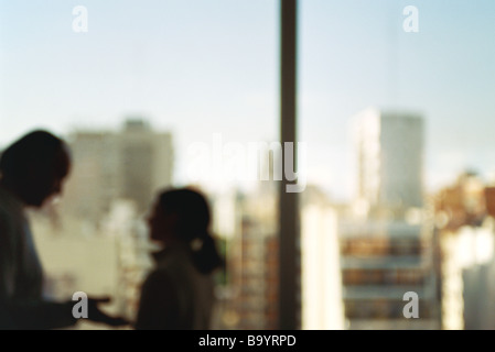 Mann und Frau von Angesicht zu Angesicht mit Gespräch, Fenster hinter silhouette Stockfoto