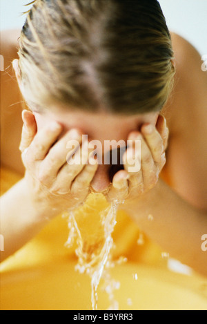 Frau Gesicht im Waschbecken waschen Stockfoto