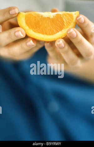 Hände halten Orangenscheibe Stockfoto