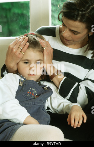 Mutter Holding Tochter Kopf Stockfoto