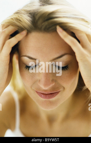 Frau läuft Händen durch das Haar, Augen geschlossen Stockfoto