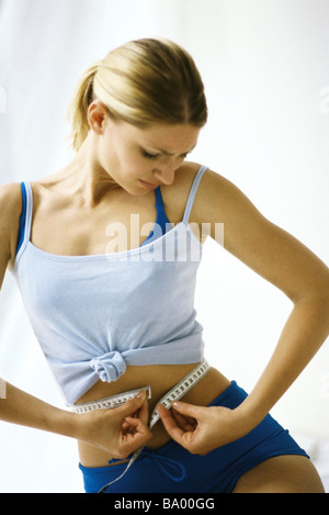 Frau im Sport Kleidung, Taille messen Stockfoto