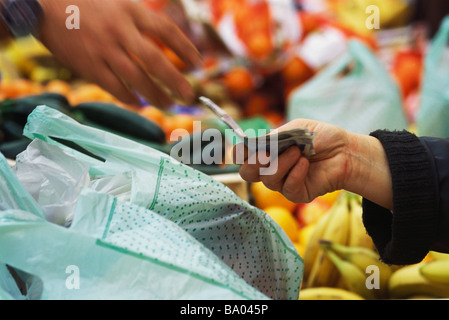 Person zahlt im Markt, verkürzte Ansicht Stockfoto