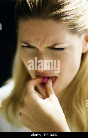 Frau Platzierung Pille auf Zunge Stockfoto