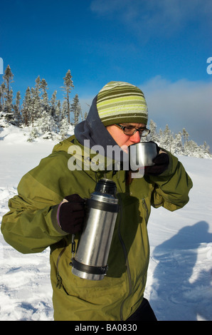 Eine Frau, die Tee trinken aus einer Flasche in Quebec winter Stockfoto