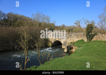 Steinbrücke über den schnell fließenden River Windrush am Minster Lovell Oxfordshire Stockfoto