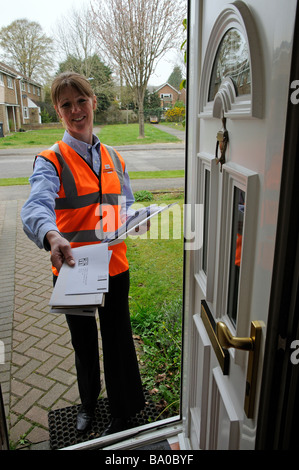 Königliche Post Briefträgerin vor der Tür eines Hauses, die Zustellung an einen Kunden Stockfoto