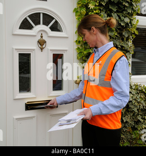 Königliche Post Briefträgerin vor der Tür eines Hauses, die Zustellung an einen Kunden Stockfoto