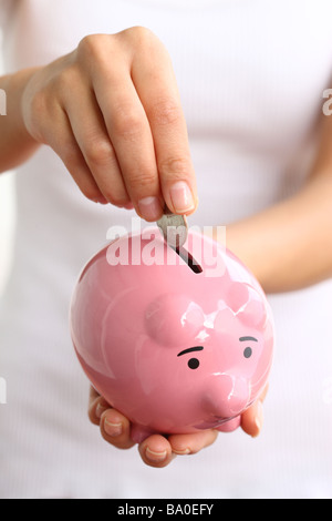 Hände halten Sparschwein Stockfoto