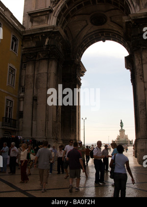 Touristen auf einem von den Einkaufsstraßen der Stadt Lissabon, die durch einen Bogen, auf einen Platz an der Küste führt Stockfoto