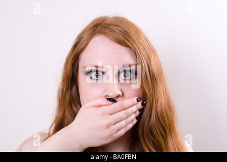 Junge Frau Hand Verkleidung Mund Stockfoto