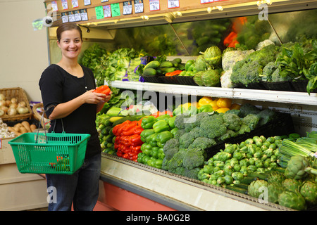 Junge Frau, die Kommissionierung Gemüse im Supermarkt Stockfoto