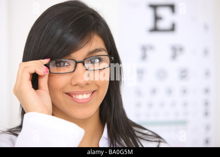 Junge Frau mit Brille Auge Diagramm im Hintergrund Stockfoto