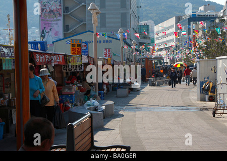 Ein Fischmarkt Straße in der Stadt Busan dekoriert mit Coloful Fahnen, mit Straße Kaufleute an der Seite der Straße Stockfoto