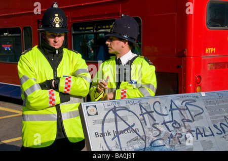 Zwei Polizisten stehen durch die Bank unterzeichnen mit Anti-Kapitalismus-Graffiti, G20-Gipfel protestiert, London, England, UK Stockfoto