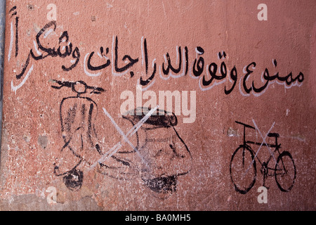 Handgemalte Schild an einer Wand in Marrakesch Warnung vor Motorräder Roller nicht zu verwenden, die Durchgang Gasse auf Arabisch geschrieben Stockfoto