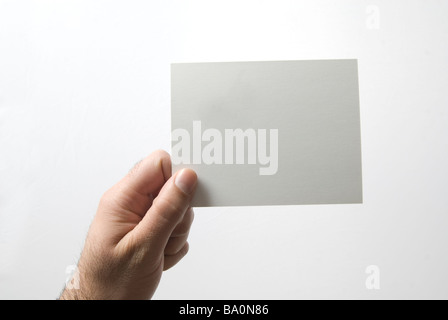 Hand mit einem weißem Karton Schild vor einem weißen Hintergrund Stockfoto