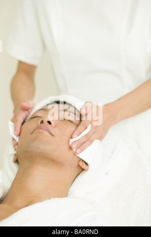 Junger Mann empfangen Gesichtsbehandlung Stockfoto