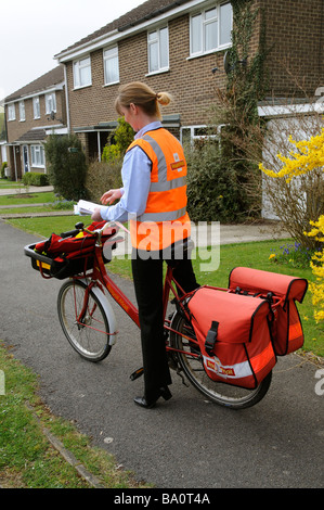 Royal Mail Briefträgerin sortieren Briefe auf ihrer Runde Stockfoto