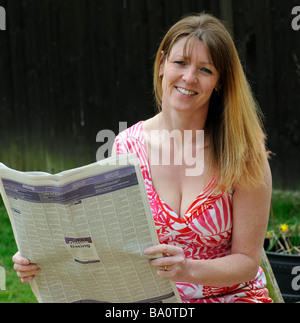 Frau Kleinanzeigen in der Zeitung lesen Stockfoto